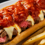 Traditional Philly cheesesteak sandwich topped with marinara sauce on a hoagie roll.