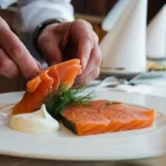 An elegant platter of smoked-salmon served with lemon slices, capers, dill.