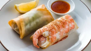 A fresh shrimp roll and a crispy egg roll placed on a plate for comparison.