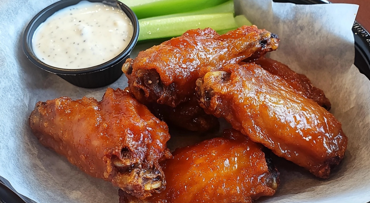 Golden-brown crispy chicken wings served with dipping sauces.