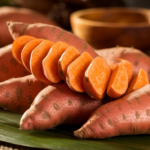 Sweet potatoes displayed next to regular potatoes on a wooden table